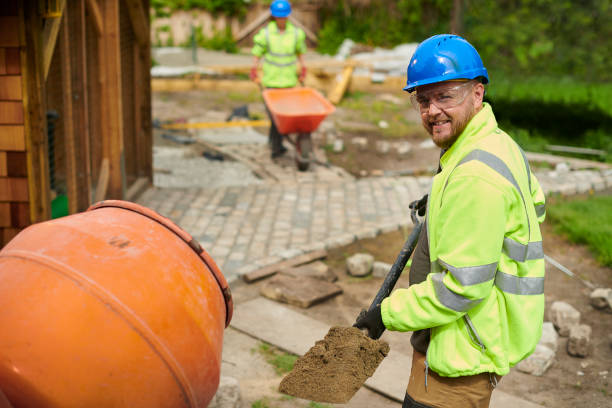 Two workers at a construction site in a residential area.